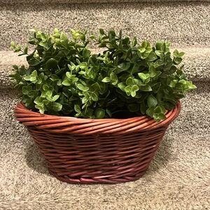 2 fake plants in wooden basket